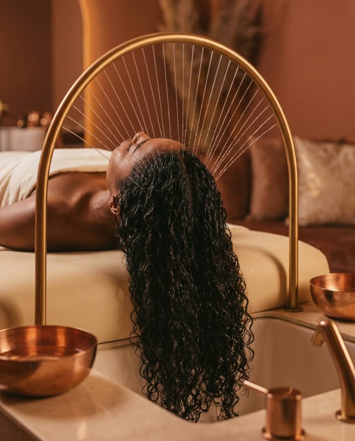 Ritual de Head Spa no Palácio das Cacheadas — arco dourado com cascata de água sobre o cabelo cacheado natural